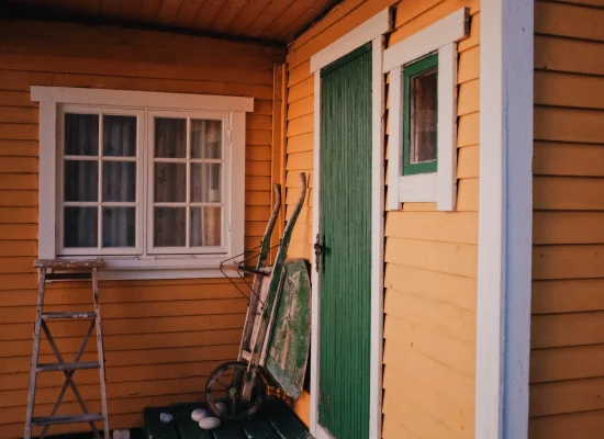yellow-house-with-green-door-and-wheelbarrow-2026-03-17-00-42-29-utc